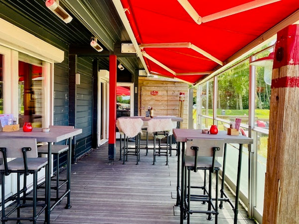 Hoge bartafel Cool met zwarte steigerbuizen en houten tafelblad voor een strandpaviljoen.