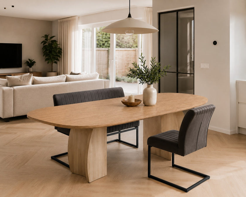 eettafel deens ovaal dualis in een woonkamer  met bank en stoel eraan geschoven.