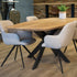 eettafel deens ovaal linea in onze showroom geplaatst met 4 witte stoelen en een blad met de kleur naturel.