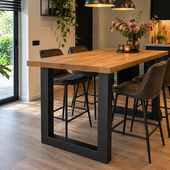 Hoge bartafel eiken met zwarte stalen U-poten in een moderne open keuken met leren barkrukken