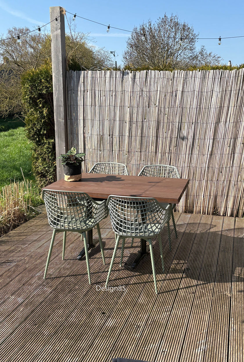 Industriële terras tafel met houten blad en zwart onderstel in zonnige tuinsetting