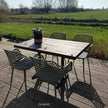 Terrastafel horeca met hout en staal op zonnig terras met natuurlijke omgeving