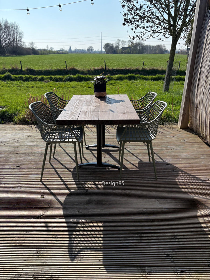 Houten horeca tafel met stalen poot op terras met tuin en bamboe schutting