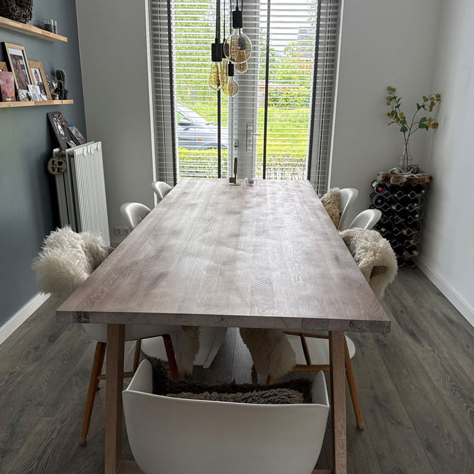 Industriele eiken eettafel heide van de kopse kant bekeken met witte stoelen