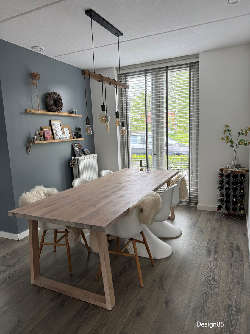 Industriele eiken eettafel heide in een mooie woonkamer met witte stoelen.