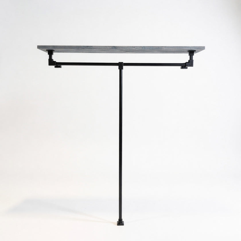 Industriële open kledingkast van zwart staal met legplank in zwarte wax op een witte achtergrond.