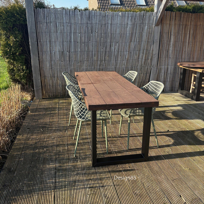 Buiten eettafel van douglas hout met zwart stalen onderstel op houten terras
