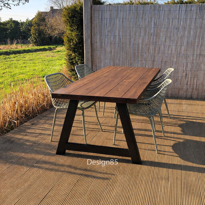Houten tuintafel met A-frame onderstel en groene stoelen op terras in de achtertuin