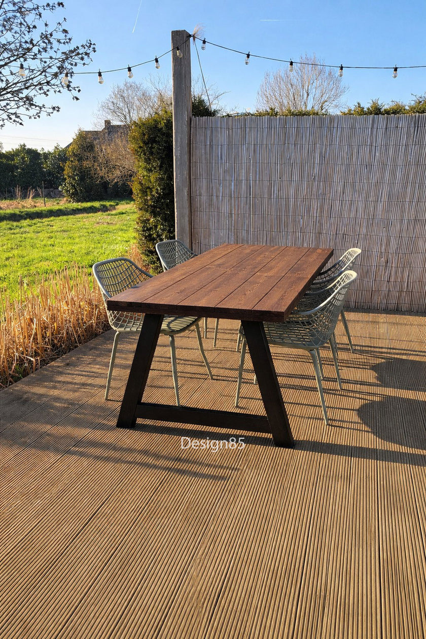 Houten tuintafel met A-frame onderstel en groene stoelen op terras in de achtertuin