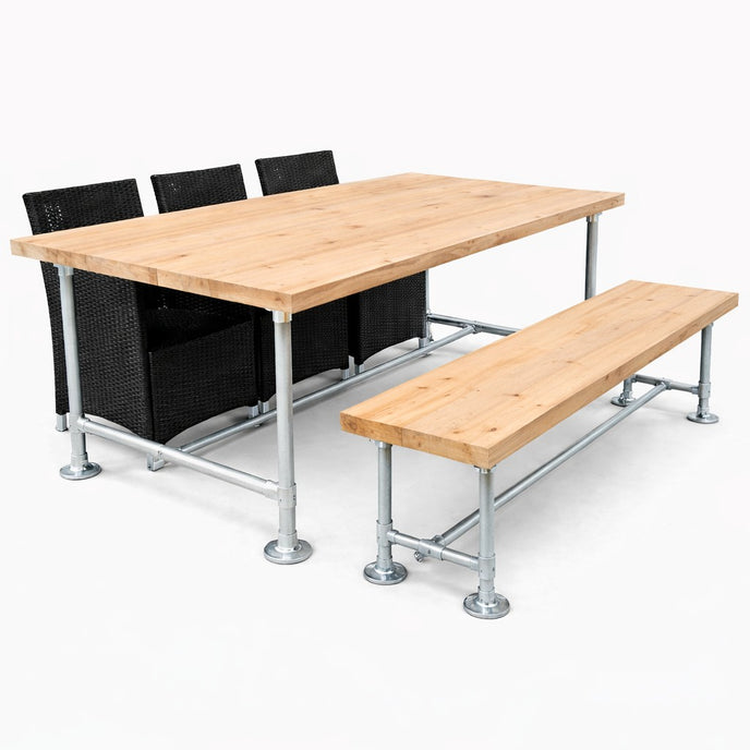 Industriële tuintafel met bijpassende bank van steigerbuizen en onbehandeld hout, gecombineerd met zwarte stoelen op een witte achtergrond.