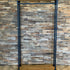 Kledingrek Display van Design85 met houten legplanken, zwarte stalen buizen en vier zwenkwielen.