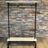 Kledingrek wielen planken van Design85 met witte houten planken, zwarte steigerbuizen en ruimte voor kleding en accessoires.