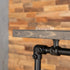 Detail van de houten bovenplank en zwarte steigerbuisverbinding van het kledingrek
