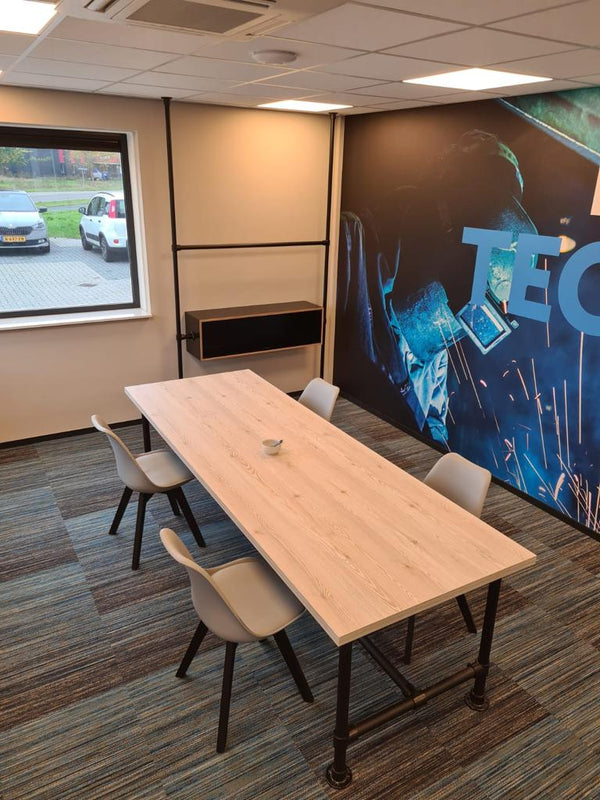 Steigerbuis tafel met zwarte steigerbuizen en melamine tafelblad als presentatie tafel op kantoor.