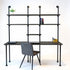 Vintage bureau met wandplanken van zwart gebeitst hout en zwart stalen buizen, modern werkplek design