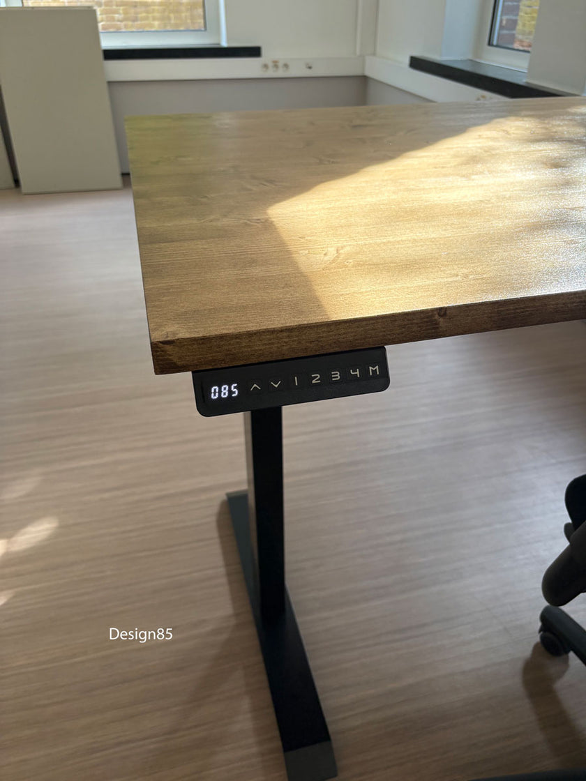 Houten zit sta bureau met elektrisch verstelbaar zwart onderstel en robuust bureaublad in een lichte werkruimte.
